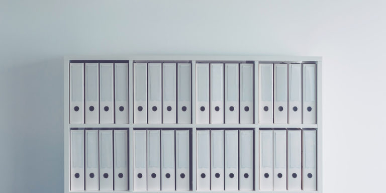 Document ring binders in business office with clock on the wall as conceptual image for fiscal year bookkeeping and tax accounting with copy space included